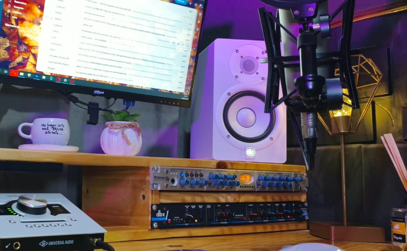 Detalhe do estúdio: microfone, monitores e mesa de som